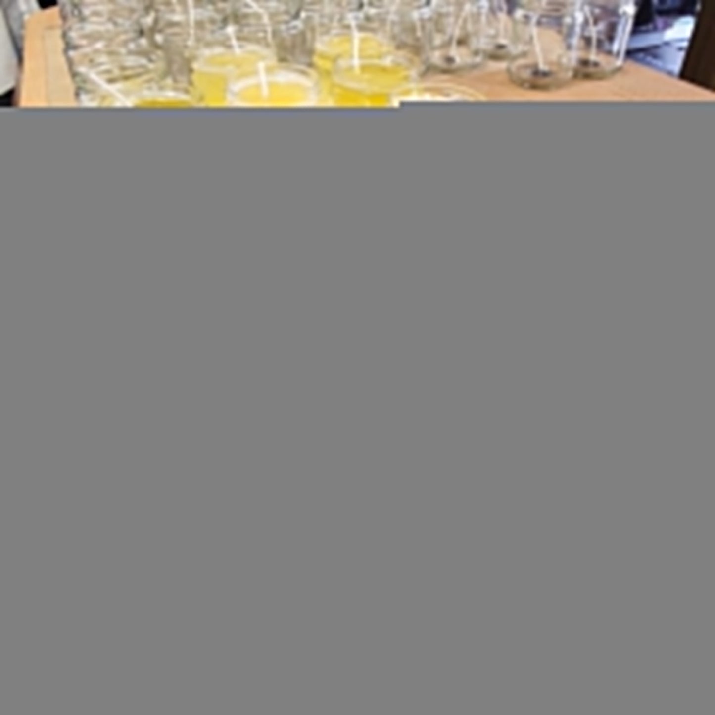 a table topped with lots of glasses filled with yellow liquid